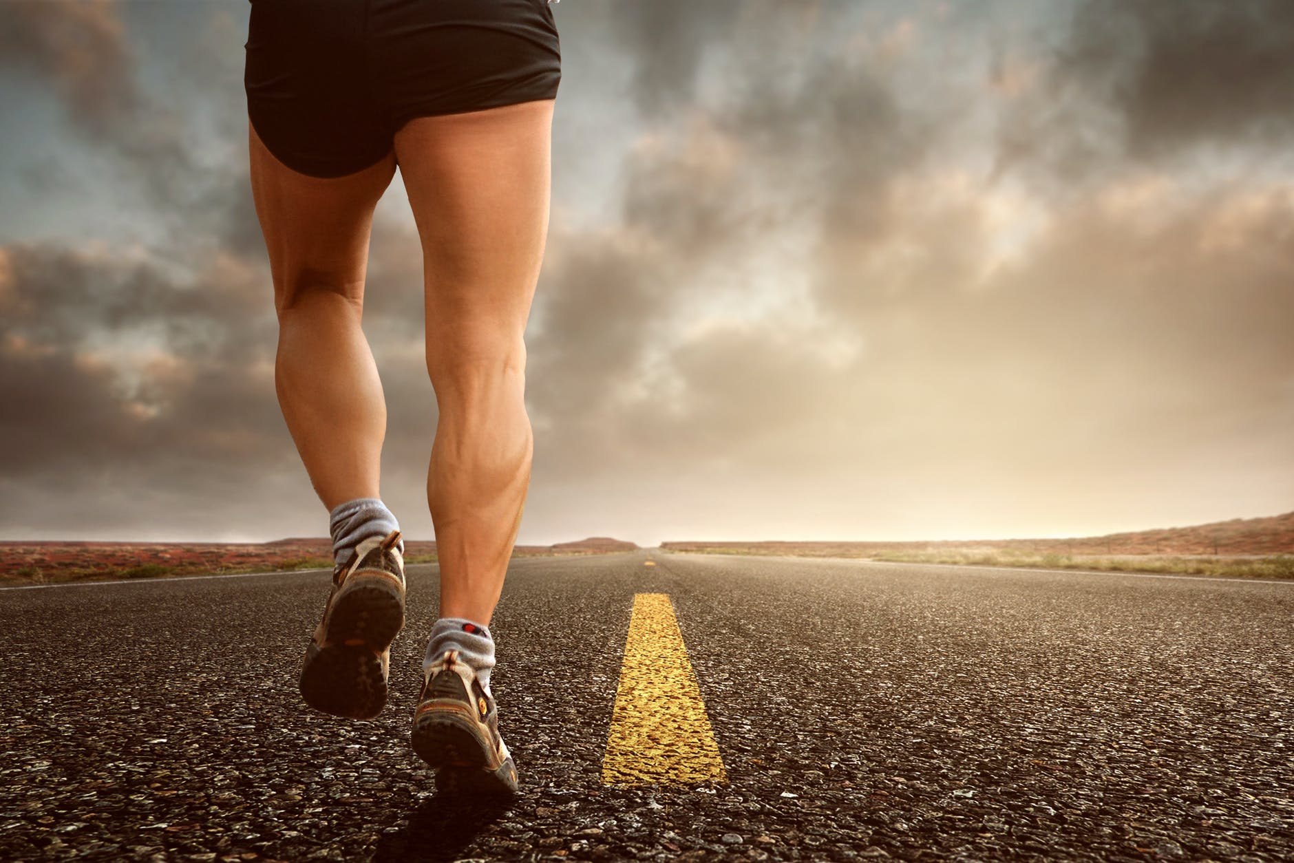 low angle photography man walking on asphalt road
